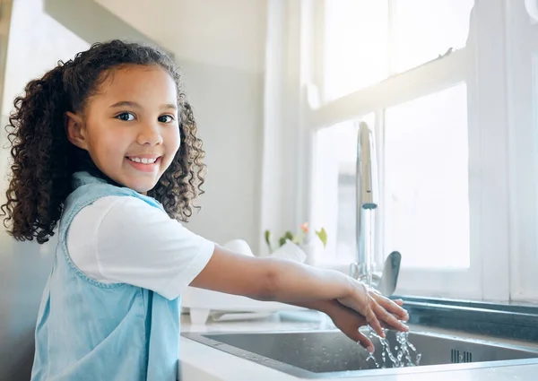 We willen nu niet het risico lopen ziek te worden, of wel? Shot van een klein meisje wassen haar handen in de gootsteen van de keuken thuis. — Stockfoto