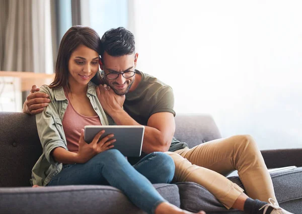 Ligado a um fim-de-semana confortável. Tiro de um jovem casal usando um tablet digital juntos em casa. — Fotografia de Stock