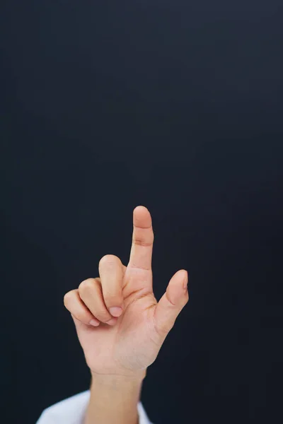 One touch will open up your medical world. Cropped shot of an unrecognizable female nurses hand while using a touchscreen interface while standing against a black background. — Stock Photo, Image