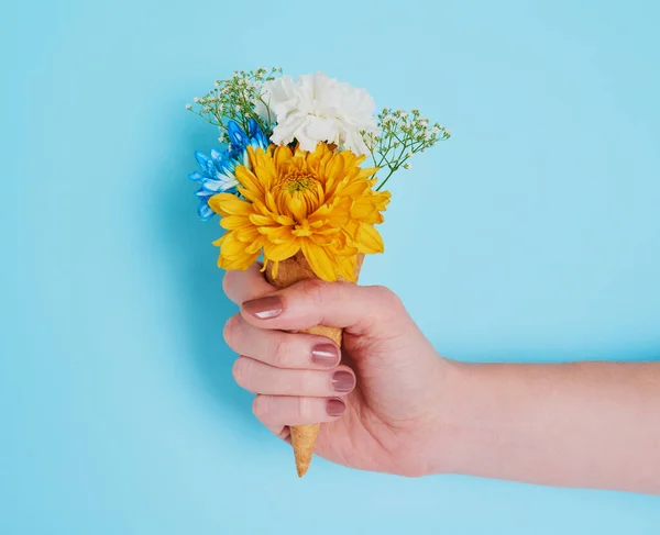 Zbyt wiele dobrego jest cudowne. Przycięte ujęcie nierozpoznawalnej kobiety trzymającej stożek nadziewany kwiatami. — Zdjęcie stockowe