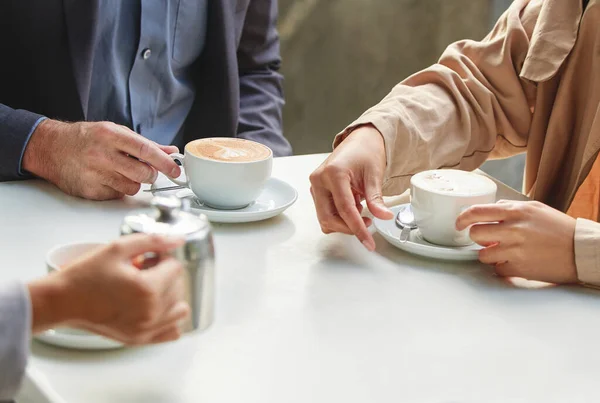Give me your best shot. Shot of a group of coworkers having a meeting at a coffee shop. — Stock Photo, Image