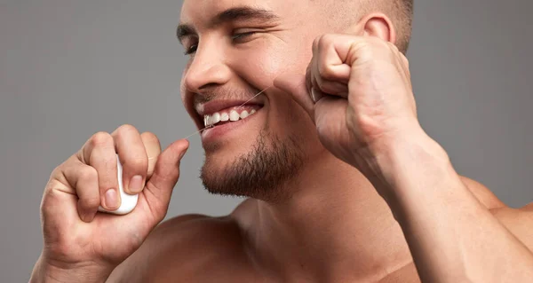Seide wie ein Chef. Studioaufnahme eines gutaussehenden jungen Mannes, der vor grauem Hintergrund die Zähne zusammenbeißt. — Stockfoto