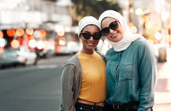 私たちはムスリムであり誇りです。街に立っている間にサングラスとスカーフを身に着けている2人の魅力的な若い女性の作物のショット. — ストック写真