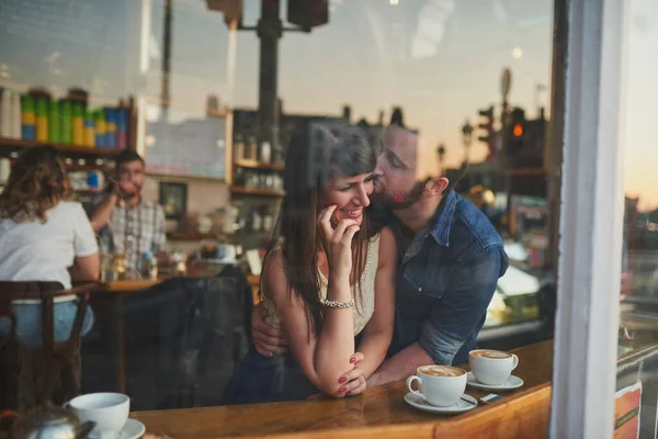 I love you.... Cropped shot of a handsome young man kissing his girlfriend on the cheek while sitting in a coffee shop during a date. — Stock Photo, Image