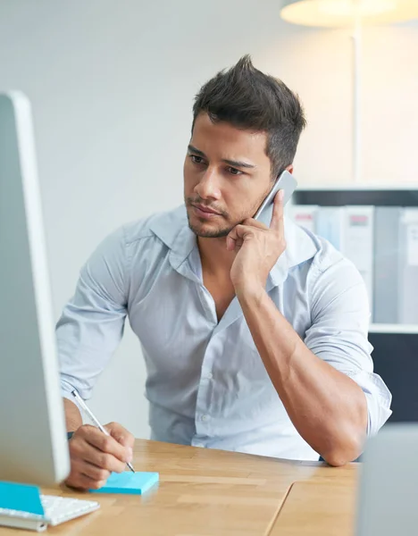 Esta noticia podría tener un efecto negativo en los negocios. Fotografía de un hombre de negocios preocupado hablando por teléfono mientras mira su computadora. — Foto de Stock