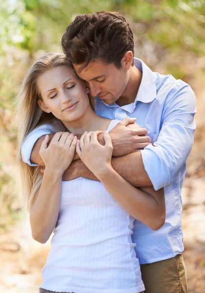 In the sunshine of their love.... Cropped view of young couple holding onto each other with their eyes closed in the outdoors. — Stock Photo, Image