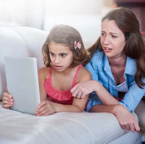Dont forget to search safely. Cropped shot of a mother and her daughter using wireless technology at home. — Stock Photo, Image