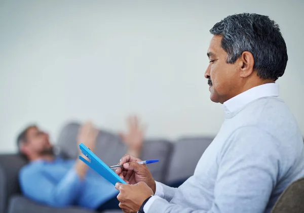 Falar é a melhor terapia. Tiro de um terapeuta tomar notas enquanto ouve um paciente durante uma sessão de aconselhamento. — Fotografia de Stock