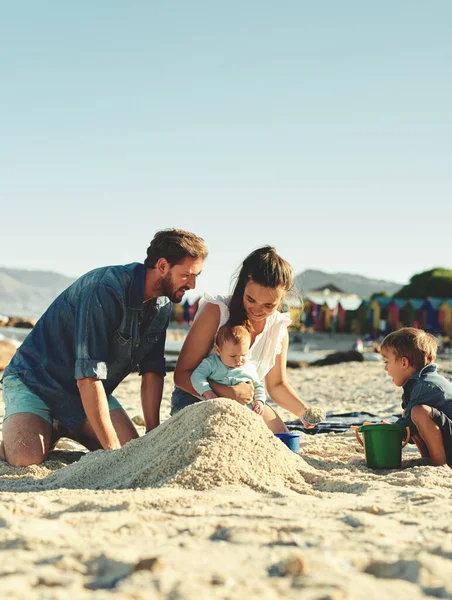 Familienvergnügen in der Sonne. Aufnahme einer jungen Familie, die Zeit am Strand verbringt. — Stockfoto