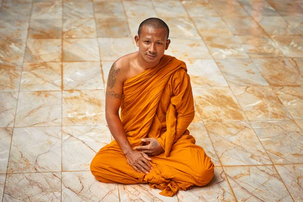 Sentada en meditación tranquila. Retrato de un monje budista sentado en el suelo de un monasterio. — Foto de Stock