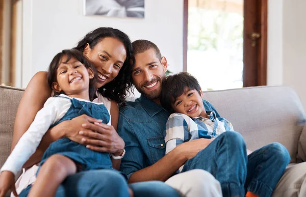 Семья значит для нас всё. Обрезанный снимок семьи из четырех человек, сидящей вместе на диване дома. — стоковое фото
