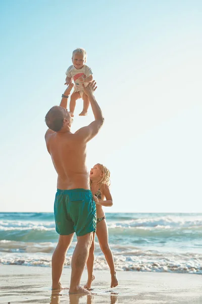 Diventerà un amante della spiaggia. Retrovisore di un uomo che trascorre del tempo con suo figlio e sua figlia in spiaggia. — Foto Stock