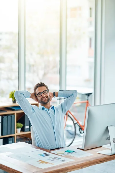 Ha sido una brisa atravesar mi carga de trabajo. Retrato de un joven empresario descansando mientras trabaja en una oficina. —  Fotos de Stock