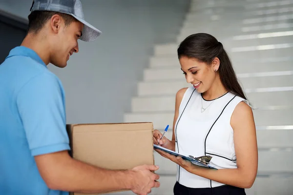 Juste à temps, comme garanti. Prise de vue d'une femme d'affaires signant pour son colis du courrier. — Photo