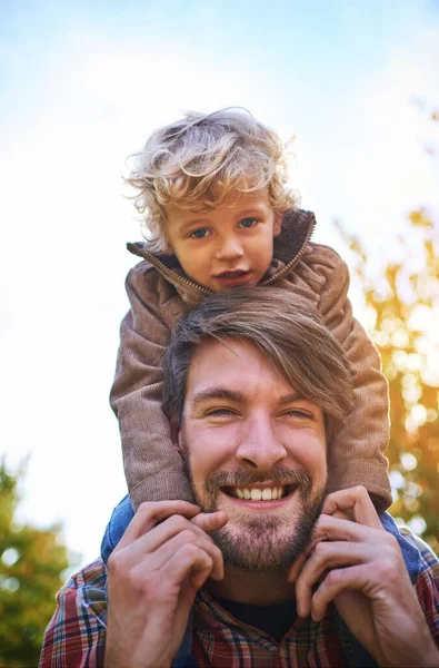Vinculándose con su hermoso hijo. Retrato recortado de un joven guapo que colgaba a su hijo afuera durante el otoño. — Foto de Stock