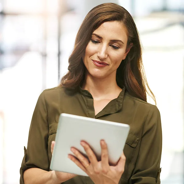 Aumentar la productividad de su negocio con la tecnología. Fotografía recortada de una joven empresaria usando una tableta digital en una oficina. —  Fotos de Stock