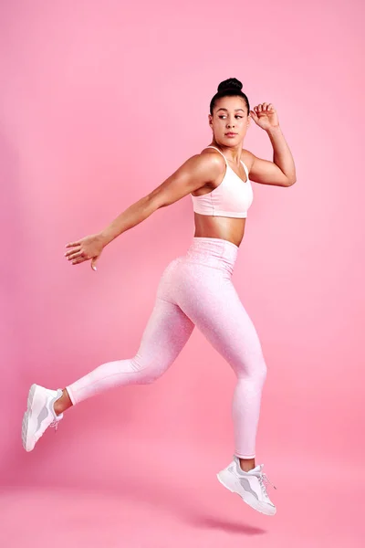 "Budu pokračovat v zapínání. Studio záběr na sportovní mladé ženy skákání na růžovém pozadí. — Stock fotografie
