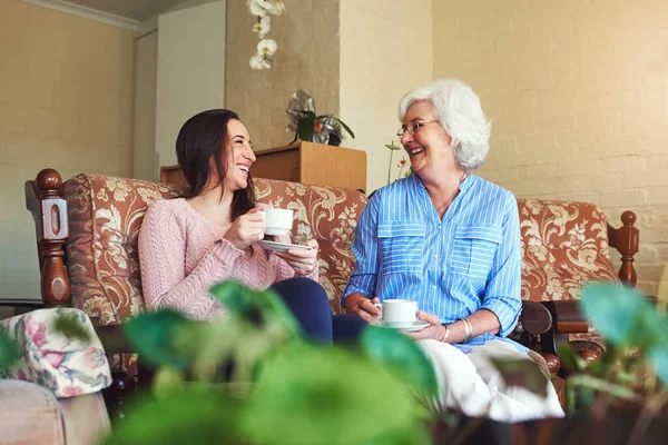 A avó adora partilhar as suas histórias do passado. Tiro cortado de uma mulher idosa e sua neta bebendo uma xícara de chá em casa. — Fotografia de Stock