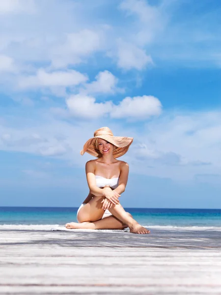 Piękne wakacje na plaży. Portret seksownej młodej kobiety w białym bikini i kapeluszu pozującej nad morzem. — Zdjęcie stockowe
