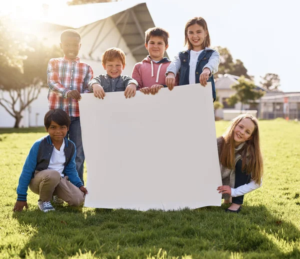 Holding up your message for their future. Shot of young kids playing together outdoors. — Stock Photo, Image