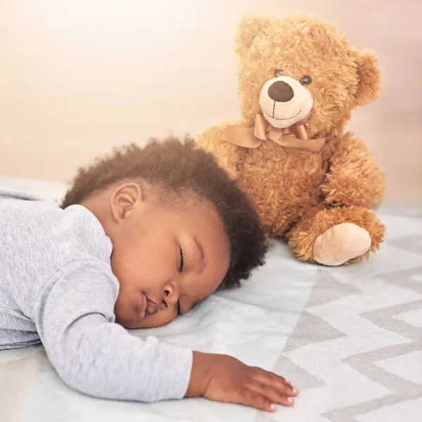 Sonha com um pequenino. Tiro de um menino dormindo em uma cama com um ursinho de pelúcia. — Fotografia de Stock