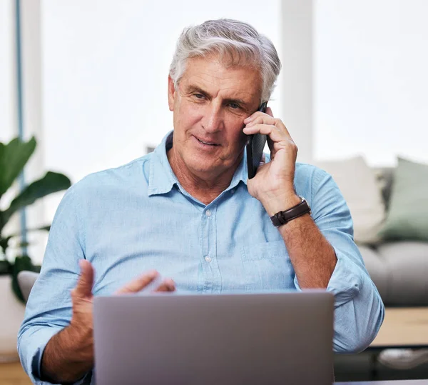 Du kan ringe når som helst. Skudt af en moden mand ved hjælp af sin mobiltelefon og bærbare computer, mens han arbejder hjemmefra. - Stock-foto