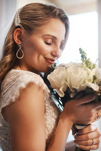 Hmm, sie riechen erstaunlich. Schnappschuss einer attraktiven jungen Braut, die allein in der Garderobe steht und ihren Blumenstrauß riecht. — Stockfoto