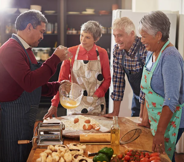 Если есть венчик, есть и способ. Фотография группы пожилых людей, готовящих на кухне. — стоковое фото