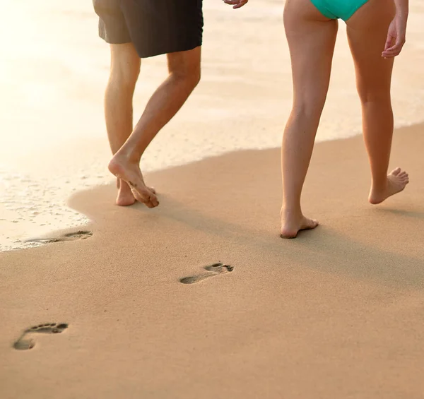 Côte à côte le long de la mer. Plan recadré d'un couple non identifiable marchant ensemble sur la plage. — Photo