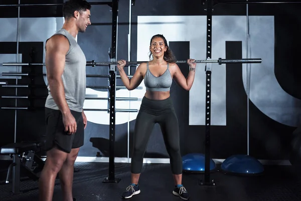 Feinabstimmung der Technik, Feinabstimmung des Körpers. Aufnahme einer jungen Frau beim Heben einer Stahlstange während ihres Trainings in einem Fitnessstudio. — Stockfoto