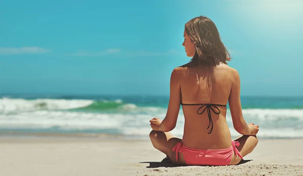 Trouver la paix au bord de l'océan. Vue arrière d'une jeune femme sexy assise sur la plage. — Photo