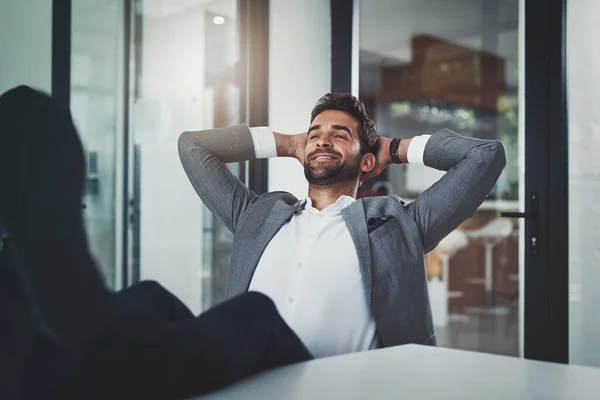 Cuando inviertes en ti mismo y valga la pena. Foto de un joven hombre de negocios guapo relajándose con los pies en un escritorio en una oficina moderna. —  Fotos de Stock