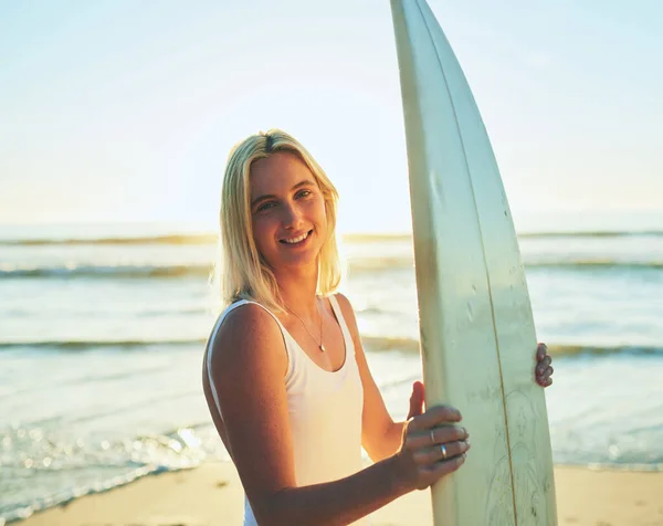 De oceaan is een droom van surfers. Gesneden portret van een aantrekkelijke jonge vrouw staande in een badpak met een surfplank op het strand. — Stockfoto