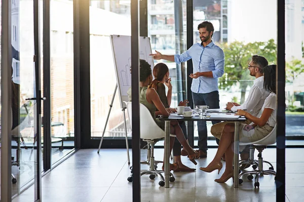 Lässt seinen Plan von der Mannschaft umsetzen. Aufnahme einer Gruppe von Geschäftsleuten bei einem Treffen in einem Sitzungssaal. — Stockfoto