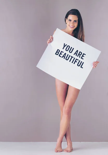 Du bist schön. Ihr seid es wert. Es reicht. Studioporträt einer attraktiven jungen Frau, die vor rosa Hintergrund ein Schild mit der Aufschrift "Du bist schön" hochhält. — Stockfoto