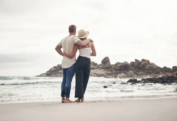 Vi elsker å komme til stranden for fred og ro. Skutt av et ungt par som tilbringer dagen sammen på stranden. – stockfoto