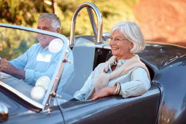 Lasst uns auf die Autobahn fahren. Aufnahme eines älteren Ehepaares, das auf einer Autoreise in einem Oldtimer sitzt. — Stockfoto