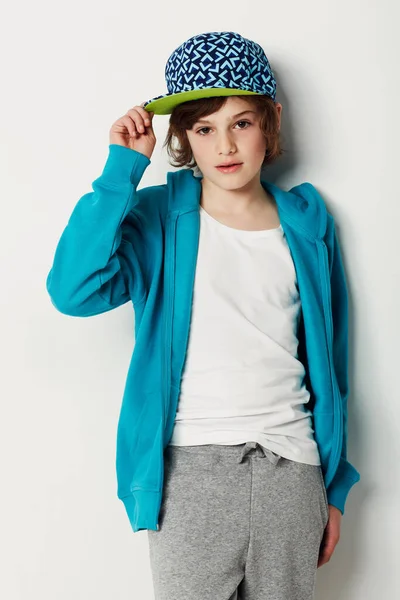 A balançar o chapéu. Bonito menino pré-adolescente vestindo roupas da moda enquanto isolado no branco. — Fotografia de Stock