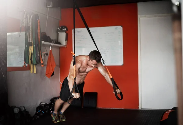 Una alternativa a las flexiones. Tiro de cuerpo entero de un joven guapo y musculoso haciendo ejercicio en el gimnasio. — Foto de Stock