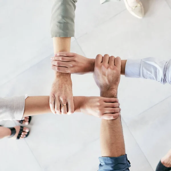 Developing a good work ethic is key. Cropped shot of a group of businesspeople linking their arms in solidarity at work. — Stock Photo, Image