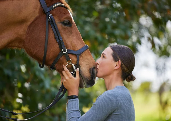 En häst galopperar med lungorna ihärdiga med hjärtat. Skjuten av en attraktiv ung kvinna stående med sin häst i en skog. — Stockfoto