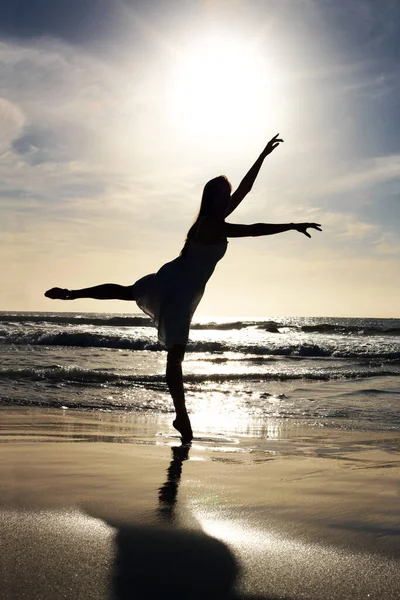 Wanita muda yang lucu menari di pantai saat matahari terbenam. Potret seorang wanita muda yang lucu menari di pantai laut Outdoor. — Stok Foto