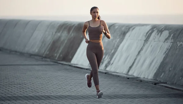 Las carreras de aire fresco son las más energizantes. Tiro de una joven deportista corriendo al aire libre. —  Fotos de Stock