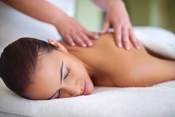 Deixá-la afastar-se das preocupações. Tiro de uma jovem mulher desfrutando de uma massagem nas costas em um spa. — Fotografia de Stock