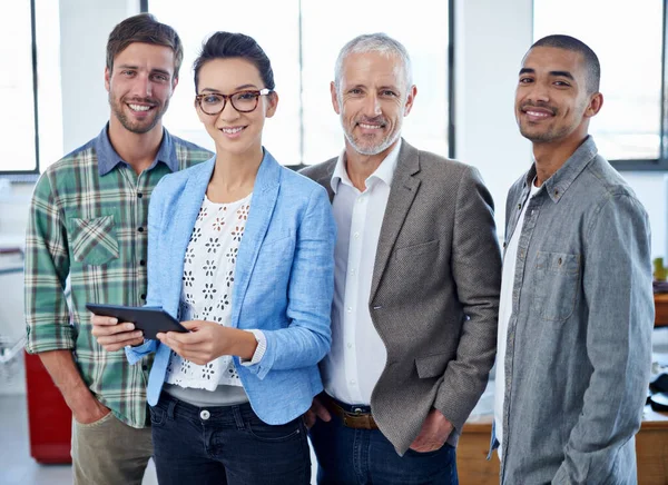 A equipa criativa número um. Retrato de um grupo de colegas usando um tablet digital em pé em um escritório. — Fotografia de Stock