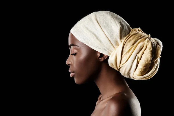 Het profiel van schoonheid. Studio shot van een mooie vrouw met een hoofddoek tegen een zwarte achtergrond. — Stockfoto