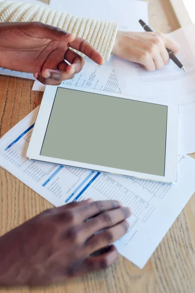 Het is de ultieme kantoorassistent. Opname van twee niet-identificeerbare teamleden die een tablet gebruiken terwijl ze samenwerken aan een tafel. — Stockfoto