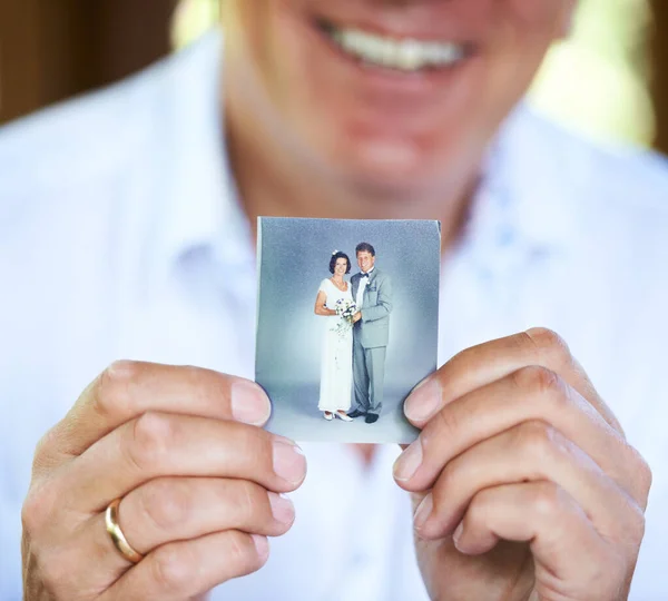 Aznap, amikor összeházasodtunk... levágott kép egy emberről, aki egy régi esküvői fotót tart a kezében.. — Stock Fotó