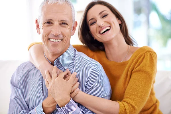 Riendo a través de la vida juntos. Shot de un hombre maduro siendo abrazado por su esposa más joven. — Foto de Stock