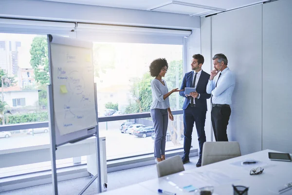 Lavorare con le loro migliori idee. Girato di un gruppo eterogeneo di imprenditori che discutono in un ufficio. — Foto Stock